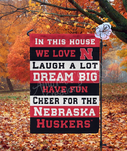 In this house we love Nebraska, laugh a lot, dream big, have fun, and cheer for the Nebraska Huskers garden flag